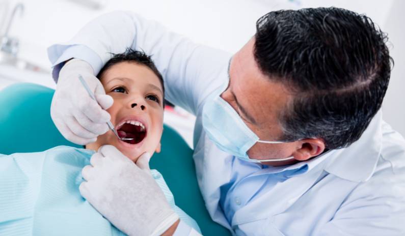 Dentist checking the teeth of a kid patient